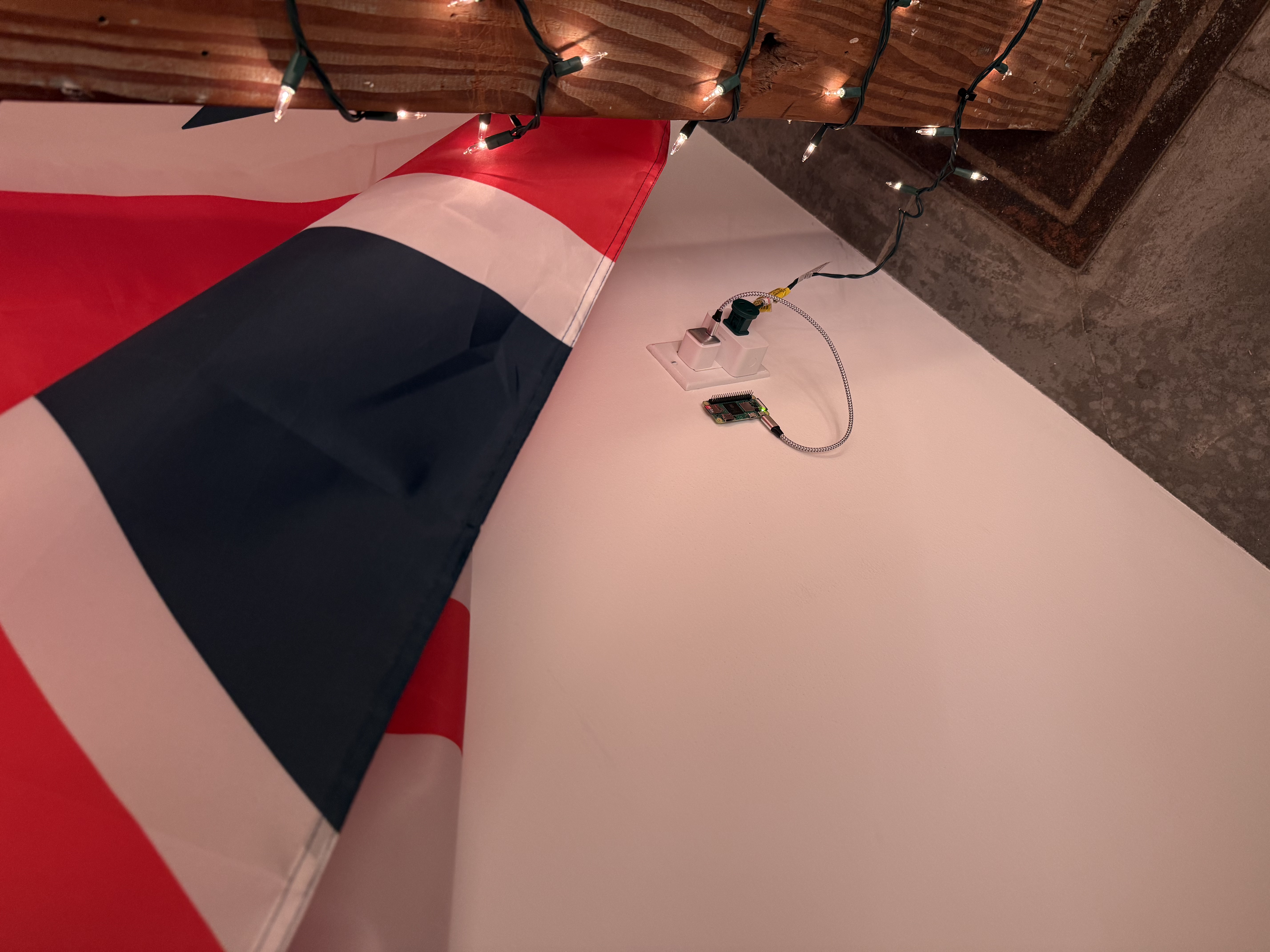 Pi-Zero 2 W mounted to the wall behind a flag